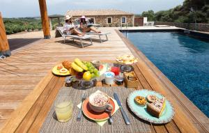 a tray of food on a table next to a pool at Villa Nicoletta in Santa Teresa Gallura
