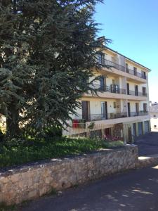 un bâtiment avec un arbre en face dans l'établissement T2 gîte de Laurette avec garage et parking privés, à Rodez