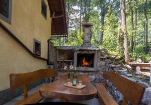 un patio con chimenea de piedra, mesa y sillas en Holiday House Vodice na Lazu en Strmica