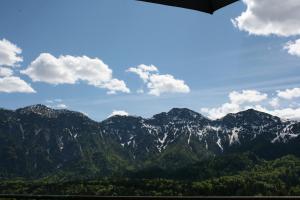 a view of a mountain range with trees and clouds at Hotel Lindwurm in Bad Goisern