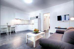 a living room with a couch and a table and a kitchen at Apartmani Dule Komiza in Komiža