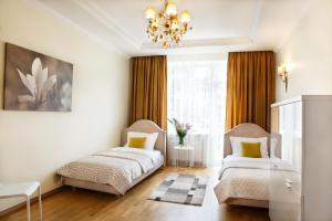 1 Schlafzimmer mit 2 Betten und einem Kronleuchter in der Unterkunft Elegance in Klaipėda