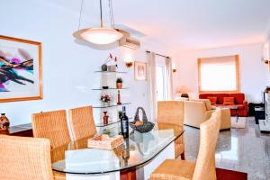 a living room with a glass table and chairs at Albufeira Elegance in Albufeira