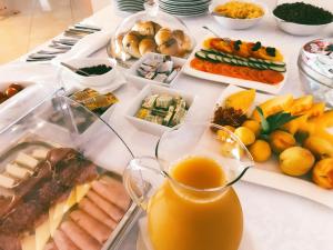 una mesa llena de comida y un vaso de zumo de naranja en Rooms Ino, en Kaštela