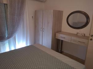 a bedroom with a bed and a mirror and a dresser at Alexandros in Aridaia