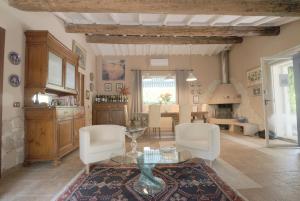 a living room with a glass table and white chairs at Podere Casanova in Pistoia