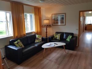 a living room with a black couch and a table at Hlidarbol Apartments in Hlíðarendi