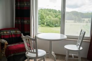 una mesa y dos sillas frente a una ventana en Aavikunurga Guesthouse, en Kõiguste