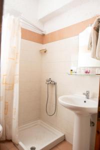 La salle de bains est pourvue d'un lavabo et d'une douche. dans l'établissement Mpezas Studios, à Igoumenítsa