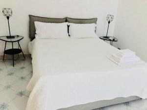 サレルノにあるDimora dei Mercantiのベッドルーム1室(白いベッド1台、サイドテーブル2台付)