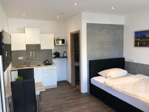 Un pequeño dormitorio con una cama y una cocina. en Hecht Apartments, en Mallersdorf-Pfaffenberg