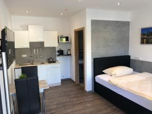 1 dormitorio pequeño con 1 cama y cocina en Hecht Apartments, en Mallersdorf-Pfaffenberg