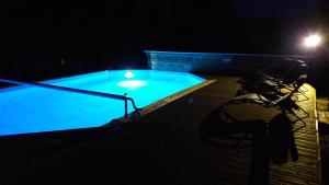 a swimming pool at night with a light in it at La Maraiquaise in Marais-Vernier