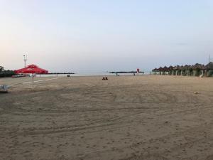 uma praia arenosa com guarda-sóis e o oceano em Appartamento Pescara Sud em Pescara