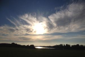 a cloud formation in the sky over a field at Thurø Rev Guesthouse in Svendborg +4 photos