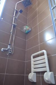 a bathroom with a shower and a basket on the wall at Dhabi Sweet Home in Doglodi +25 photos