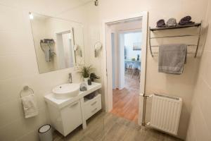 un bagno bianco con lavandino e specchio di Lake View Apartments a Keutschach am See