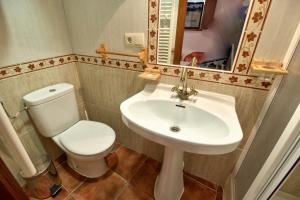 a bathroom with a sink and a toilet and a mirror at cuencaloft escapada al casco antiguo in Cuenca