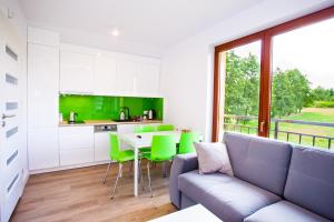 a living room with a couch and a table with green chairs at Apartamenty SaltApart2 in Wieliczka