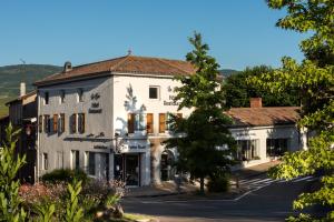 a large white building with trees in the foreground at La Rose in Juliénas