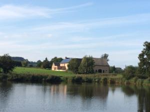 a barn next to a river with a house at Gite des étangs à Montzen in Plombières