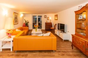 a living room with two orange couches and a tv at Apartma Spaans in Radovljica