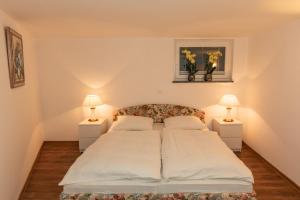 a bedroom with a large bed with two lamps at Apartma Spaans in Radovljica