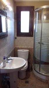 La salle de bains est pourvue de toilettes, d'un lavabo et d'une douche. dans l'établissement Ammolofoi Villa Maria sea view, à Néa Péramos