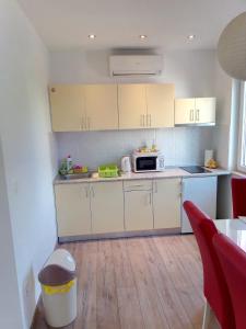 a kitchen with white cabinets and a microwave at Apartment Luka in Makarska