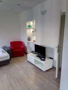 sala de estar con TV y silla roja en Apartment Luka, en Makarska