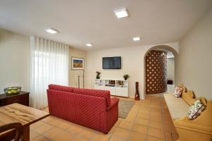 a living room with a red couch and a table at Up Estalagem dos Padres in Albergaria-a-Velha