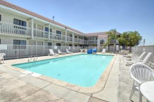a swimming pool with chairs and a hotel at Vagabond Inn Buttonwillow North I-5 in Buttonwillow
