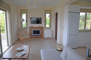 Una sala de estar con un sofá y un televisor. en Villa Magdalena, en Lixouri
