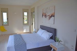 Un dormitorio con una cama grande y una silla amarilla. en Villa Magdalena, en Lixouri