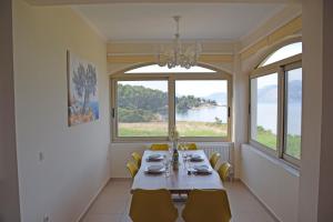 una sala da pranzo con tavolo e una grande finestra di Villa Magdalena a Lixouri