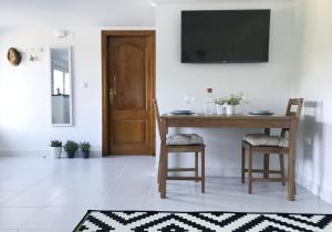 フォスにあるNuevo Apartamento Fazouroのダイニングルームテーブル(椅子2脚付)、壁掛けテレビが備わります。