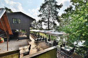 a deck with tables and chairs on a house at "Seklytele" apartments in Birštonas