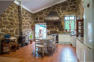 ポーヴォア・デ・ラニョゾにあるVilla Moura - Pool & Jacuzziの石壁のキッチン(テーブル、椅子付)