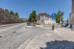a cobblestone street with cars parked on the road at Ana`s Houses in Guimarães