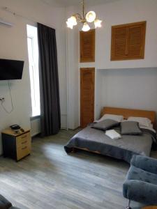 a bedroom with a bed and a tv and a chair at Grata Apartments - Kiev in Kyiv