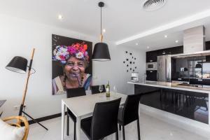 una mujer mayor está sentada en una mesa en una cocina en Luxury Holiday Apartment in Puerto Banus Marina with sea views en Marbella