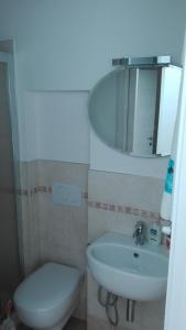 ein Badezimmer mit einem WC, einem Waschbecken und einem Spiegel in der Unterkunft Casa Greta in Massarosa