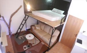 Cette petite chambre comprend un lit et un canapé. dans l'établissement Apartman Lena Loft - best value, best choice!, à Osijek