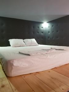 Schlafzimmer mit einem großen weißen Bett mit einem schwarzen Kopfteil in der Unterkunft Apartman Lena Loft - best value, best choice! in Osijek