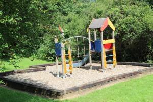 a playground with a slide and a swing at Au bois charmant in Waulsort