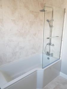 a shower with a glass door in a bathroom at Spire View Townhouse in Ballycastle