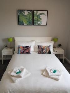 a large white bed with two towels on it at Spire View Townhouse in Ballycastle