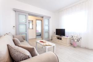 ein Wohnzimmer mit einem Sofa und einem TV in der Unterkunft Guest House Simoni in Prigradica