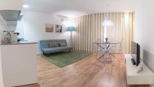 a living room with a table and a couch at Bracara Guest House "Mosteiro" - "Falperra" in Braga