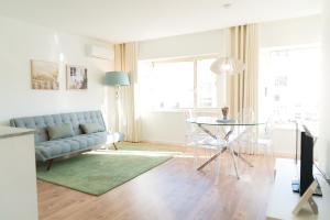 a living room with a couch and a glass table at Bracara Guest House "Mosteiro" - "Falperra" in Braga